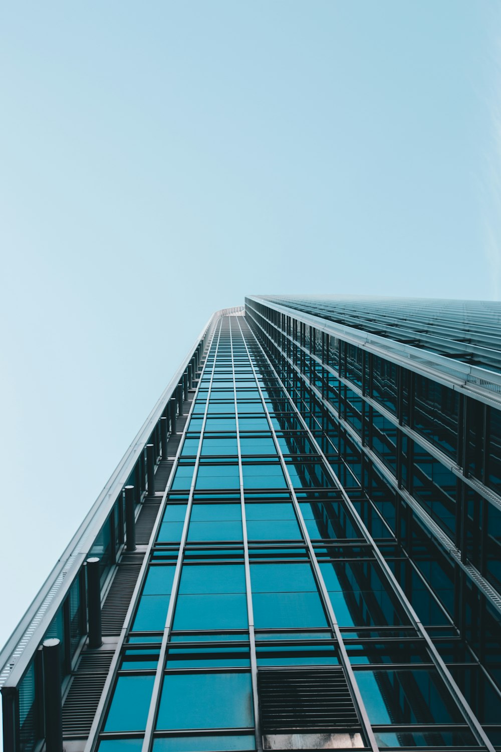 Fotografía de ángulo bajo de un edificio de gran altura de vidrio transparente