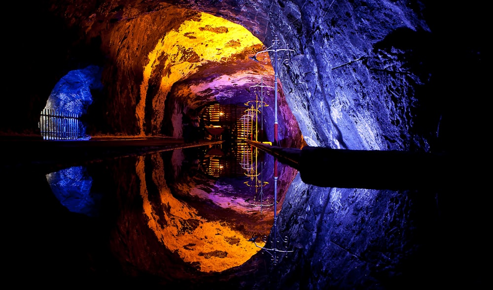 a tunnel with a reflection of a building in the water