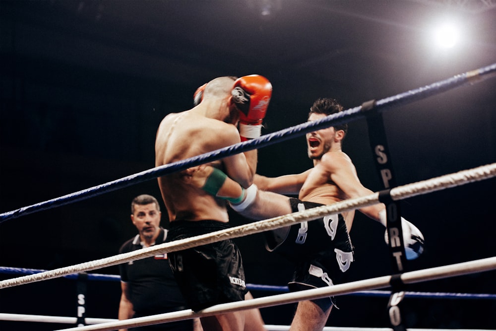 Dos personas haciendo artes marciales mixtas en el estadio blanco y azul