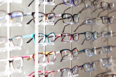 A display of colorful eyeglass frames arranged neatly on a wooden table.