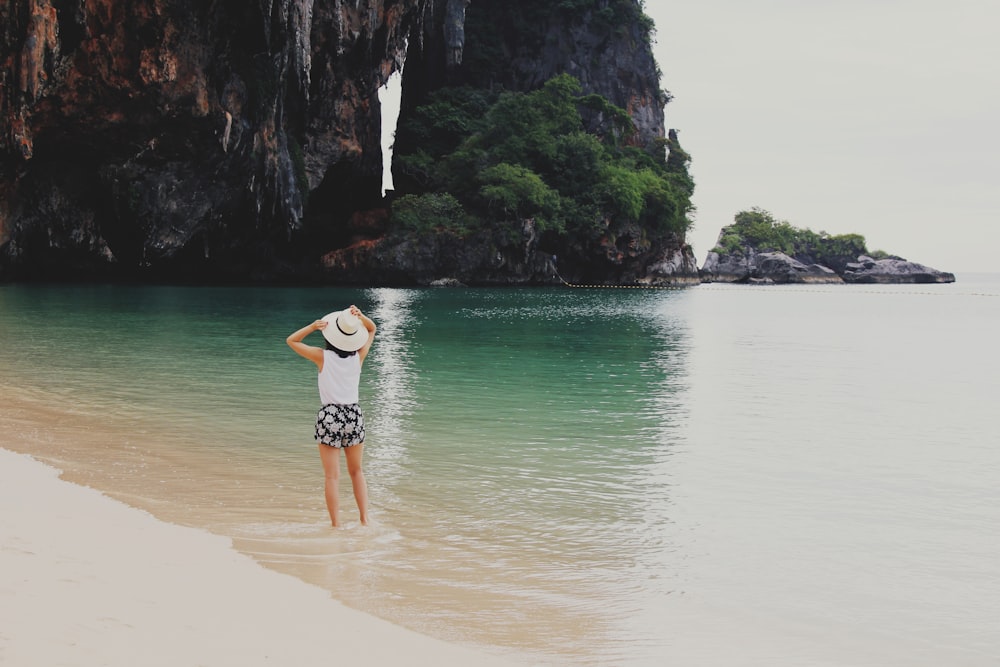 woman on body of water beside mountain