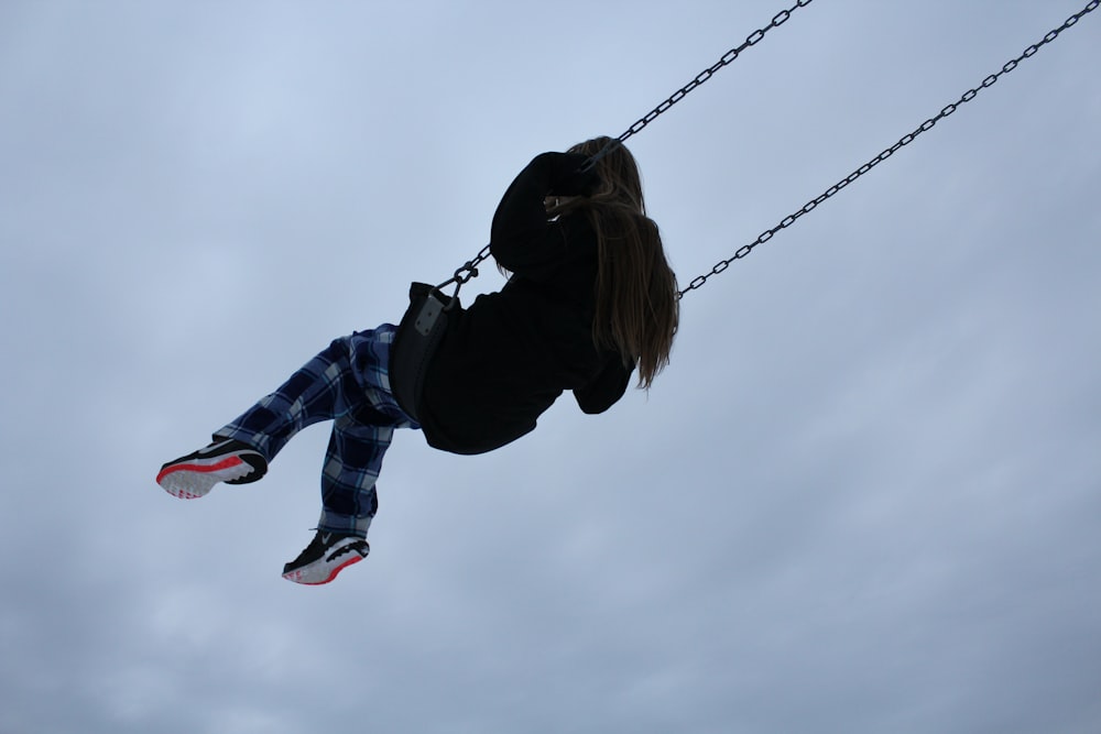 girl swinging during daytime