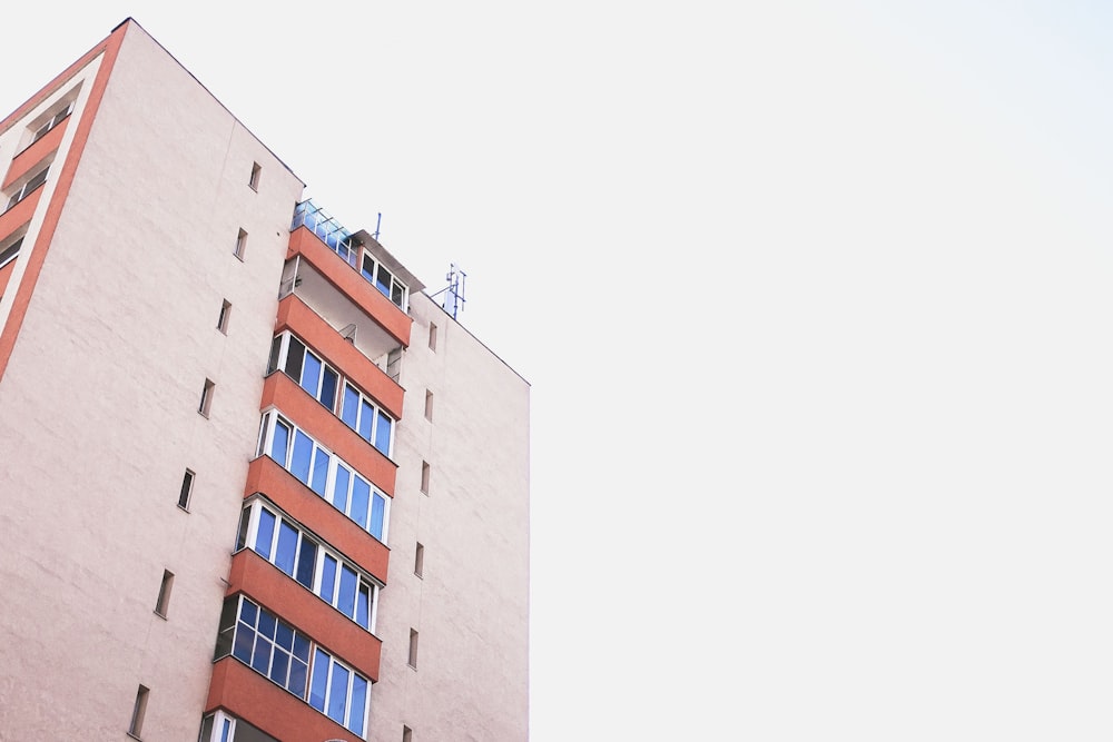 orangefarbenes und blaues Hochhaus bei klarem Himmel