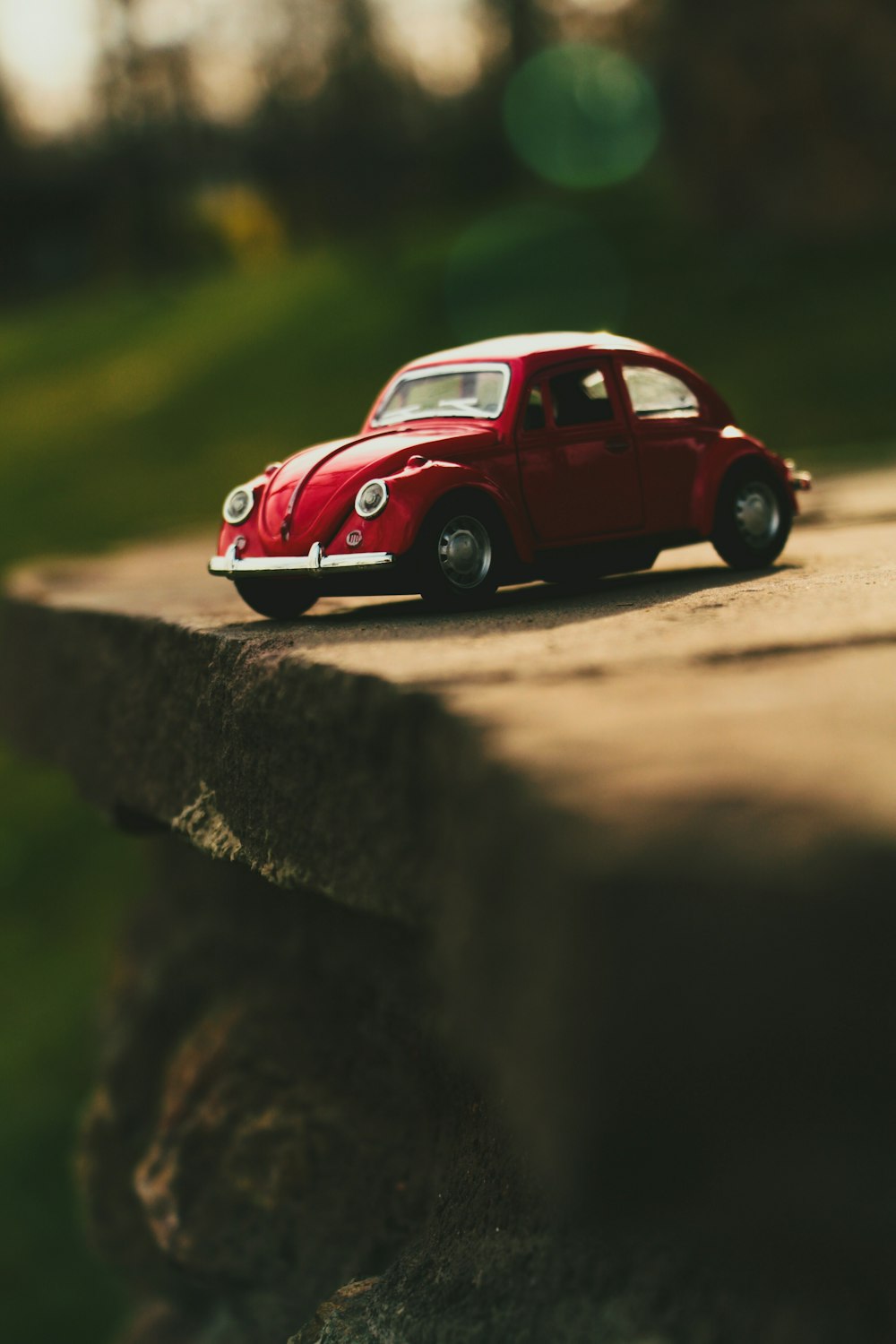 red Volkswagen Beetle scale model on grey concrete board