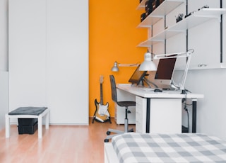 silver iMac turned off on white wooden desk