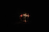 A group of diverse individuals holding candles in unity.