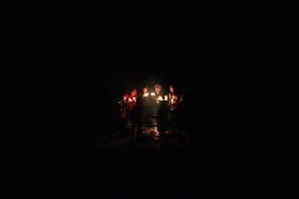 A warm community circle holding lit candles during a reflective faith gathering.