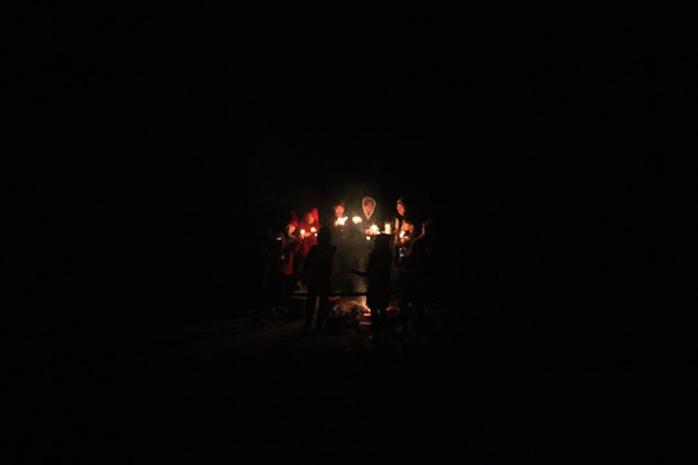 A warm gathering of diverse individuals sharing stories around a glowing candle, symbolizing living faith.