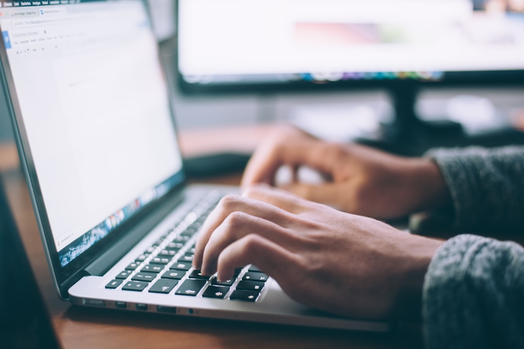 A person typing on their laptop to learn more about knowledge management with AI.