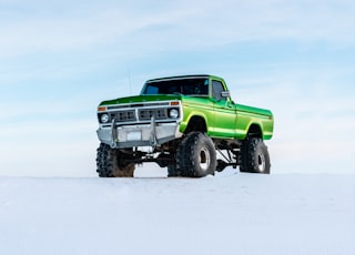 green off-road vehicle on snow during winter season