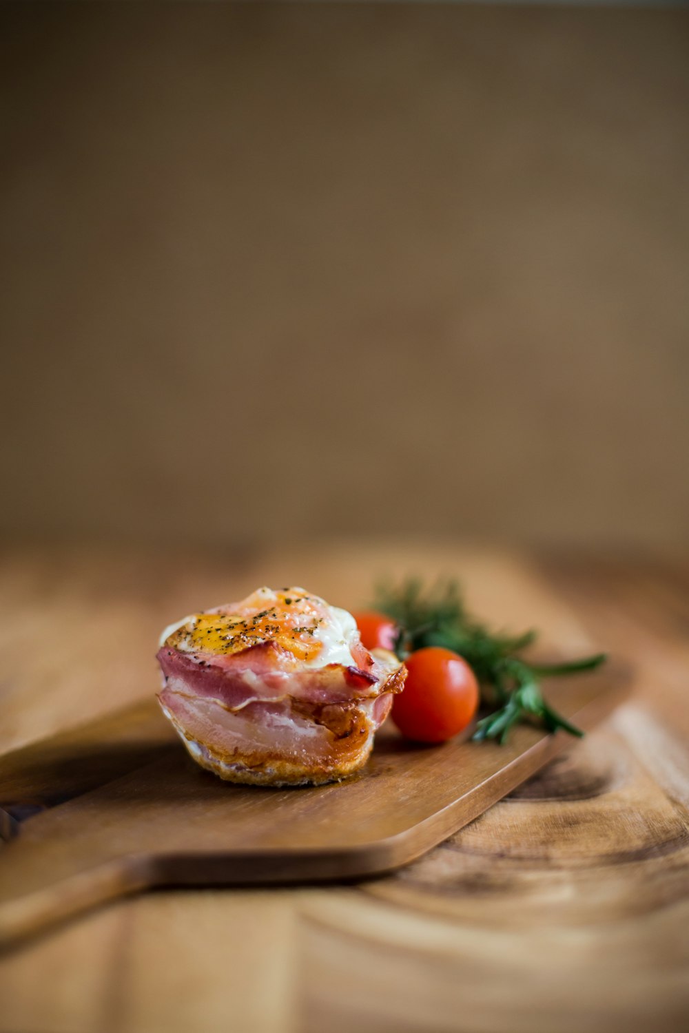 Selektive Fokusfotografie von gekochtem Essen in der Nähe von Tomaten, beide auf braunem Holzschneidebrett