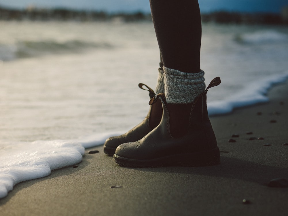 person standing on shore beside body of water during daytime