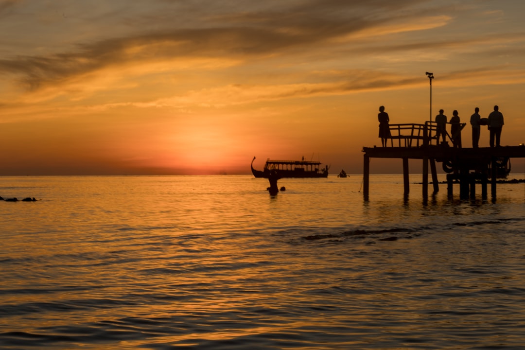 photo of people on sea dock during sunset