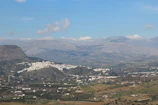 A rider pausing near a whitewashed village under a clear blue sky in the Almanzora valley.