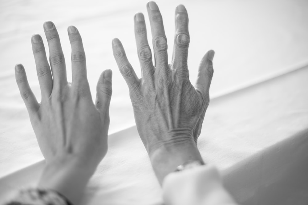 persons left hand on white textile