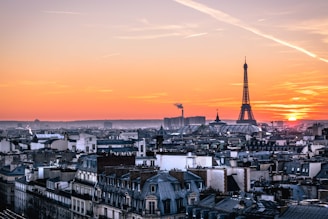 Sunset view over the Eiffel Tower with lively Parisian streets below.