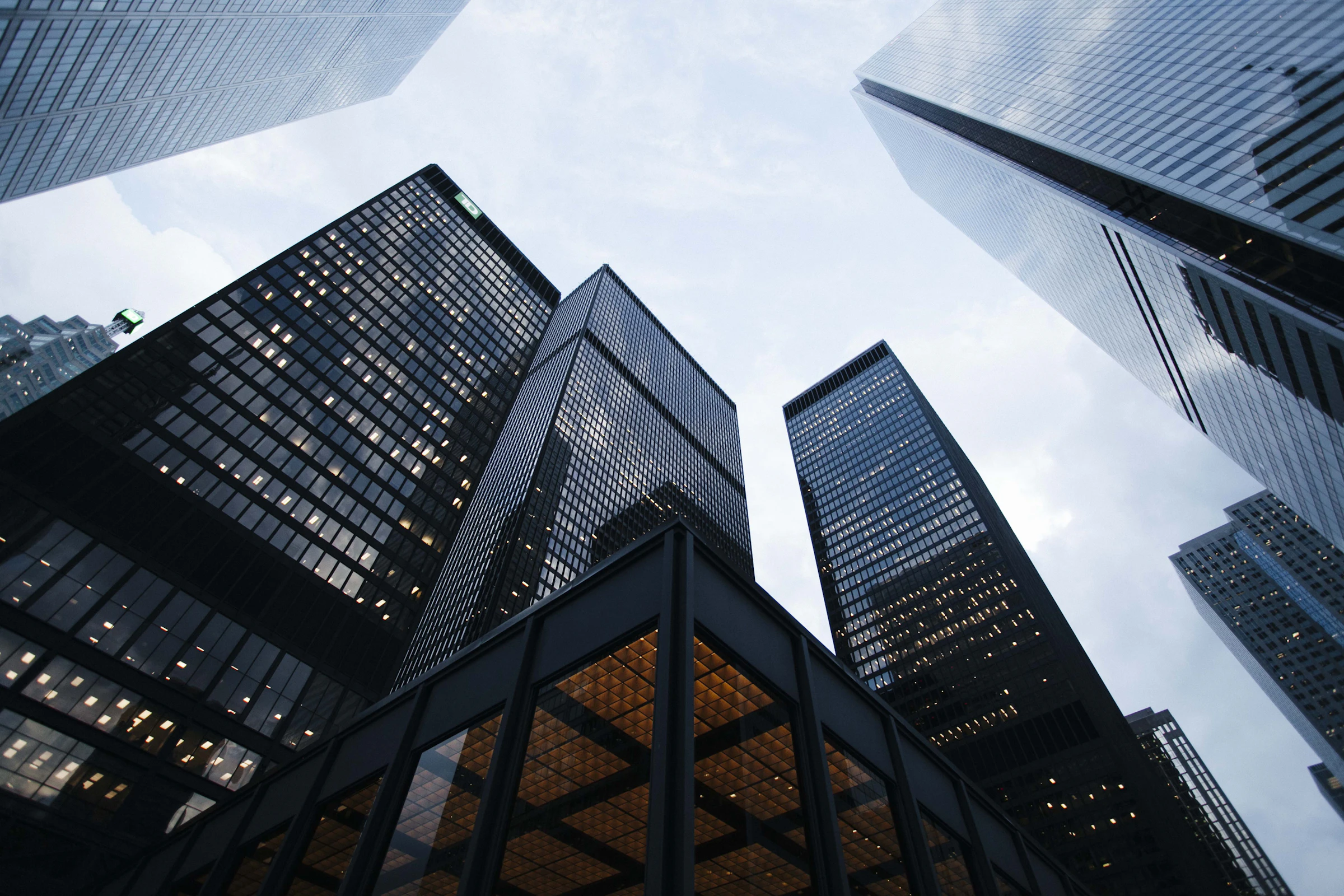Commercial office towers photographed looking upward against a pale sky