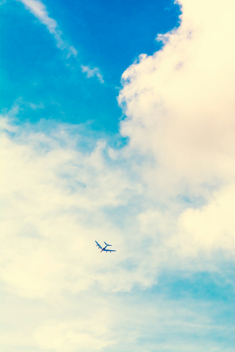 foto ad angolo basso dell'aeroplano e delle nuvole bianche durante il giorno