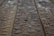 Drops of water scattered across a wooden surface, highlighting the wood grain texture. The surface appears wet with varying sizes of water droplets.