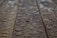 Drops of water scattered across a wooden surface, highlighting the wood grain texture. The surface appears wet with varying sizes of water droplets.