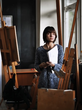 woman holding art book inside art studio