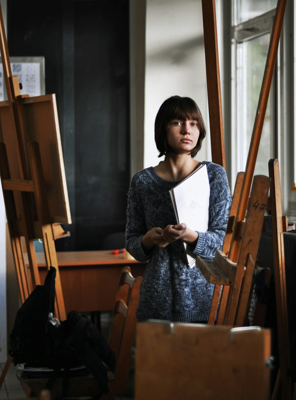 woman holding art book inside art studio