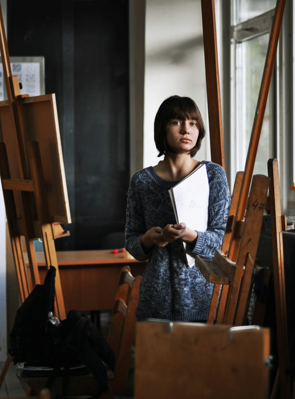 アートスタジオでアートブックを手にする女性