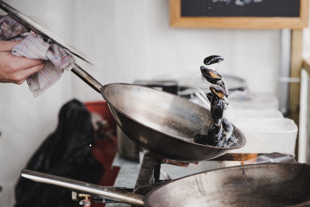 personne tenant une casserole de cuisson grise