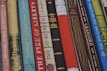 A collection of colorful e-book covers arranged neatly on a wooden desk.