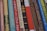 A collection of classic books with various titles lined up vertically, showcasing their colorful and patterned spines. Each spine features unique typography and designs, indicating a mix of genres and authors.