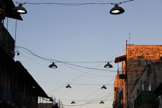 Construction workers installing lighting systems on a city street at sunset.
