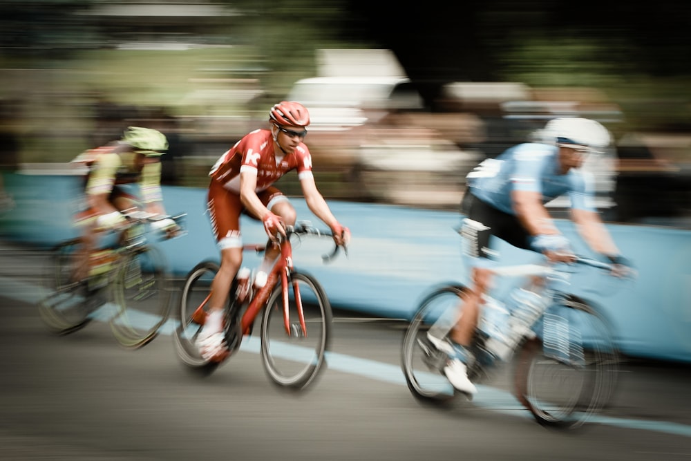 Fotografía de lapso de tiempo de tres hombres montando bicicletas en la carretera