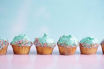 six teal icing cupcakes with sprinkles