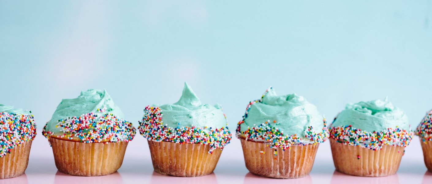 six teal icing cupcakes with sprinkles