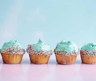 six teal icing cupcakes with sprinkles