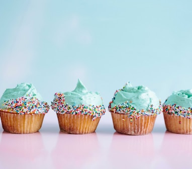 six teal icing cupcakes with sprinkles