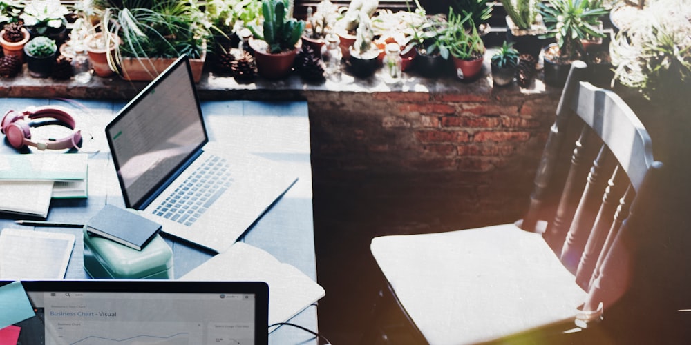 MacBook on table in front of empty chair