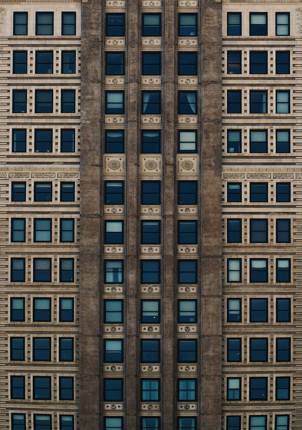 日中は青いガラス窓のある茶色のコンクリートの建物
