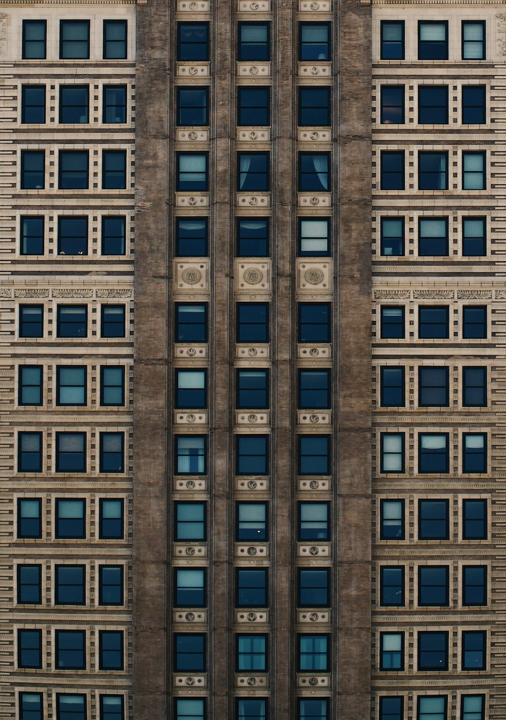 brown concrete building with blue glass windows during daytime