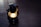 A vintage lantern with a lit bulb casting a warm glow, placed on a dark wooden surface.
