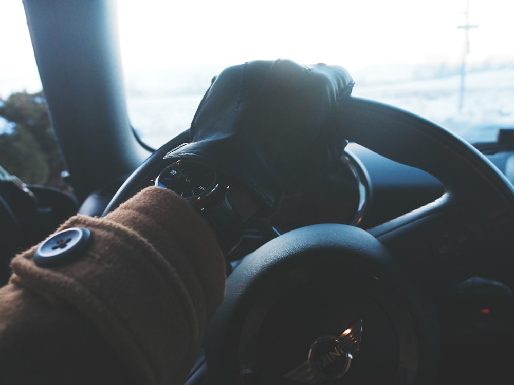 person holding black steering wheel