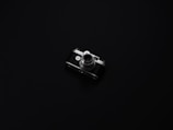 A vintage camera with metallic and black elements is centered on a minimalist, dark background. The camera's intricate details, such as the lens and dials, are highlighted by the low lighting, creating a sense of nostalgia and elegance.