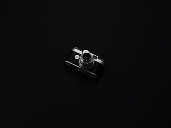A sleek, elegant film camera set against a minimalist dark background, symbolizing refined audiovisual craftsmanship.
