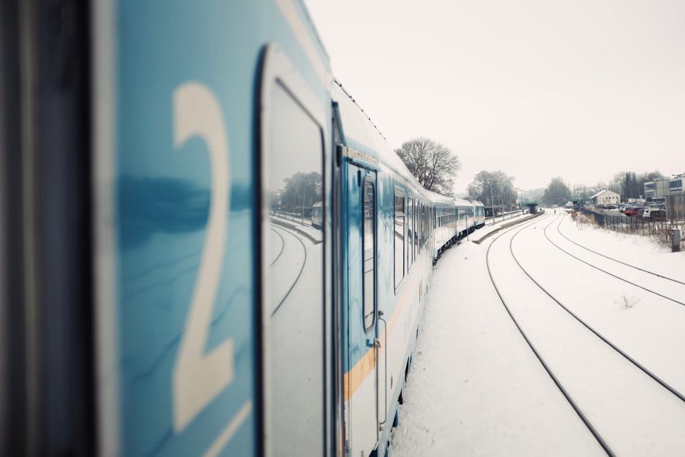 blauer Zug neben Häusern