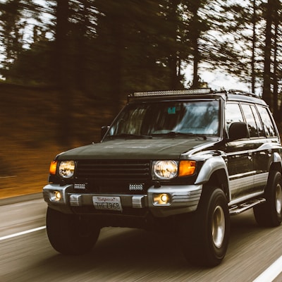 timelapse photography of green SUV on road