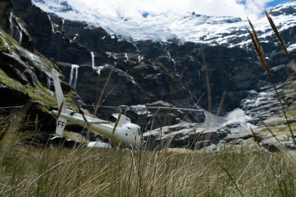 white helicopter near the snow capped mountains