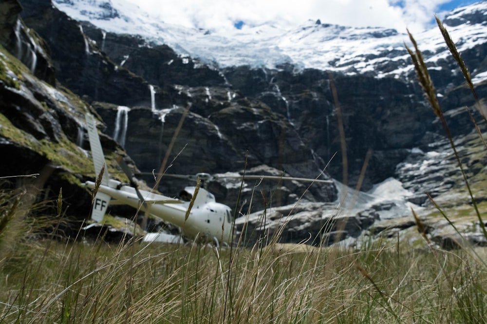눈 덮인 산 근처의 흰색 헬리콥터