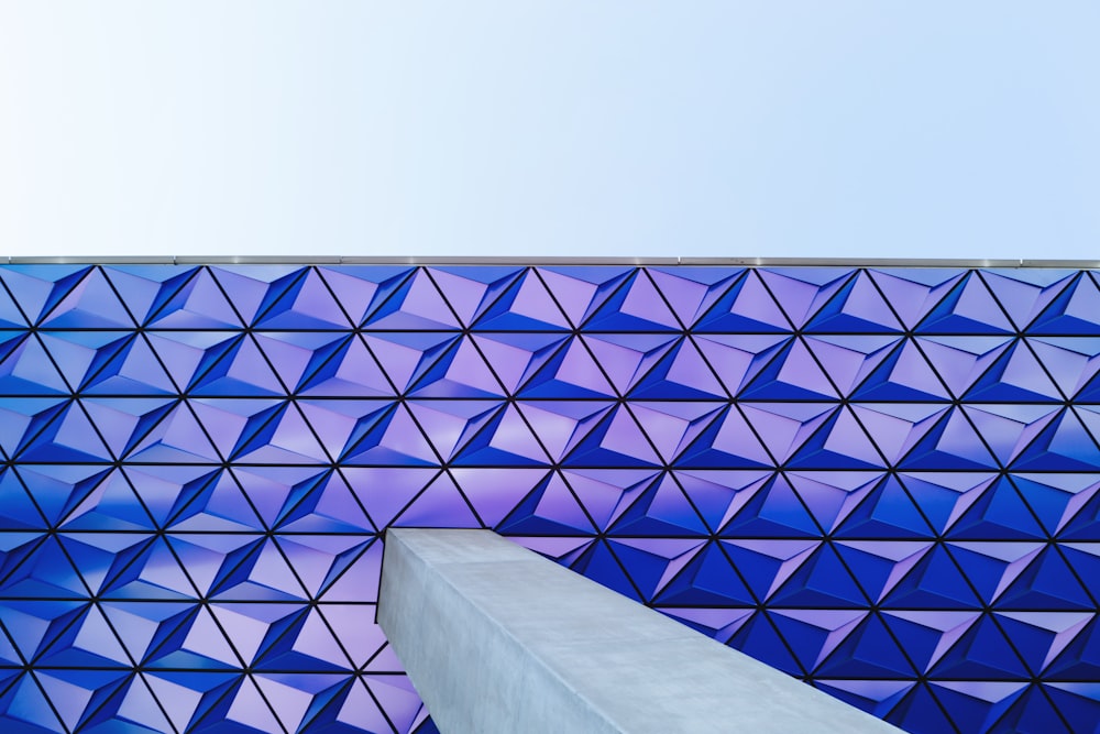 a tall building with a very large blue wall next to it