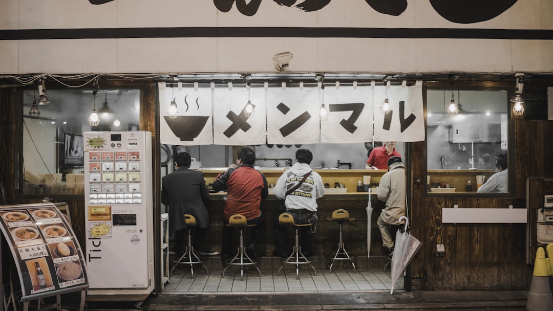 four person sitting on bar stools, In Japan
