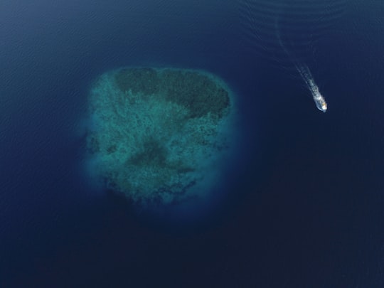 aerial photograph of boat near island under water in Addu City Maldives